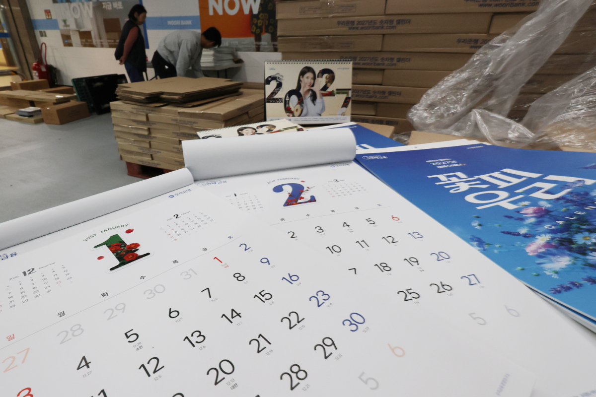 La foto, tomada el 28 de octubre, muestra los calendarios para 2027 abiertos por las páginas de enero y febrero, en la sede central del banco Woori Bank, en el distrito de Jung-gu, en Seúl. 